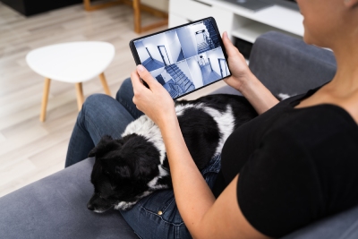 Une femme regarde une vidéosurveillance de son habitation.