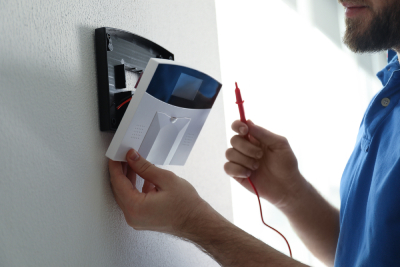 Un spécialiste installe un boîtier d'alarme